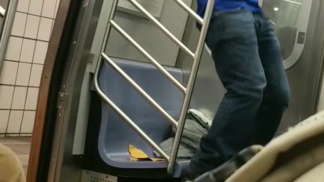 Guy black hat blue shirt doing pull ups subway