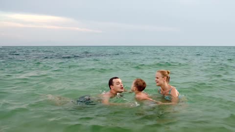 family playing with a ball in the shore