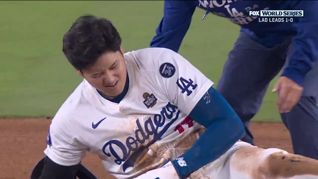 Shohei Ohtani leaves the field with a trainer after attempting to steal 2B in the 7th inning