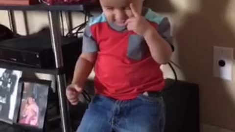 Kid in red shirt throws water and ends up hitting himself in the face