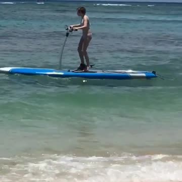 Surfboard peddle scooter beach guy