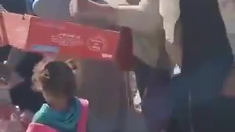 Israeli soldiers distributing water to Palestinians in northern Gaza—something