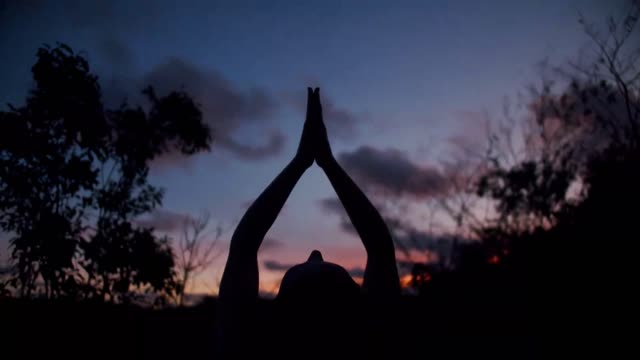 Woman practicing yoga at night