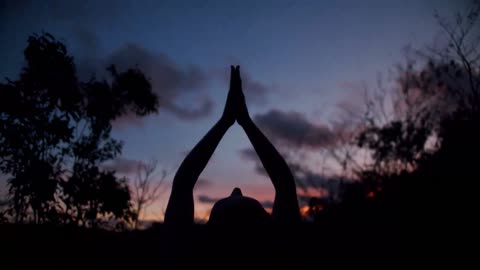 Woman practicing yoga at night