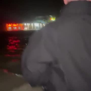 Deputies wading on foot through flood waters on Fort Myers Beach
