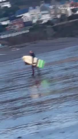 White surfboard guy walking across beach oh no