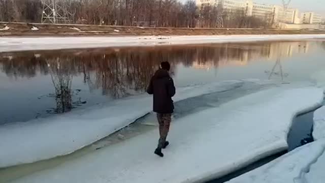 A crazy dumb man kicks a dead dog and falls under a frozen river