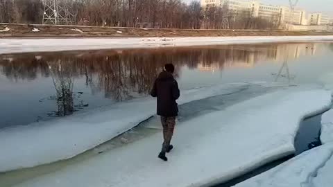 A crazy dumb man kicks a dead dog and falls under a frozen river