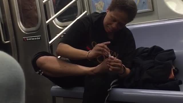 Man cuts toenails on subway