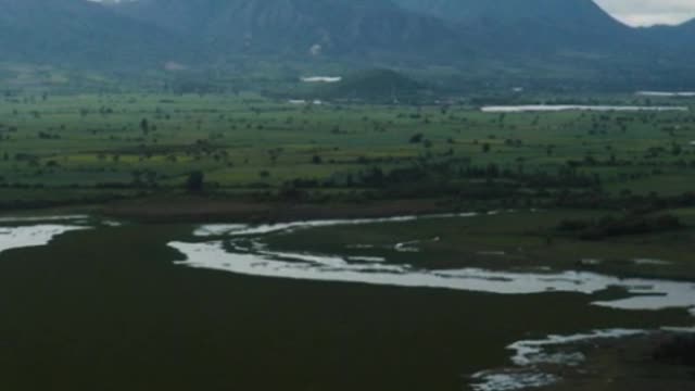 Landscape of a great plain with a lake, trees and mountains around