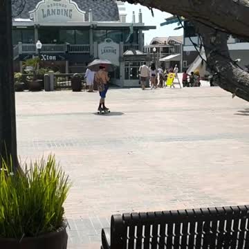 Guy orange hat skating shirtless umbrella