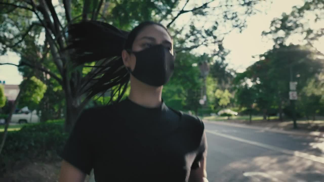 Young woman running with mask on the street