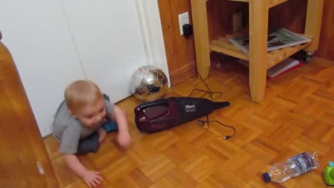 The child is afraid when the vacuum cleaner is turned on, at the same time he plays with it