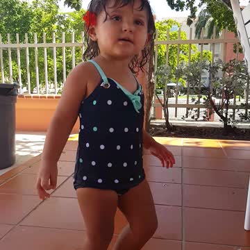 Little girl dances by the pool
