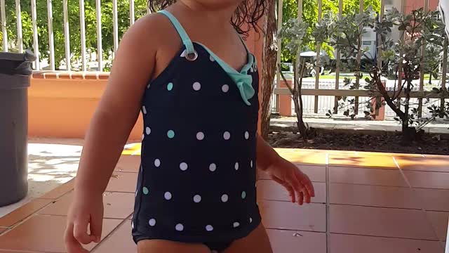 Little girl dances by the pool