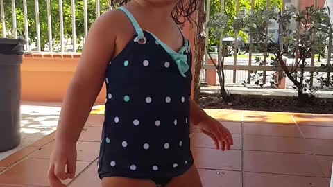 Little girl dances by the pool