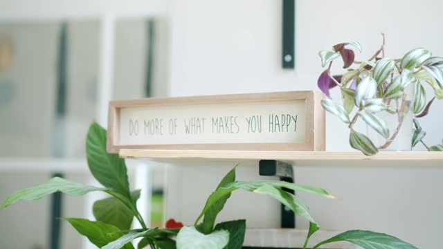 A Hand Placing a Sign with a Phrase on a Shelf