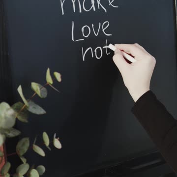 Writing A Message In A Blackboard Using A Chalk