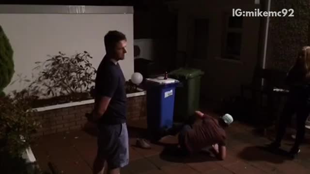 Small man kicks tall man in black