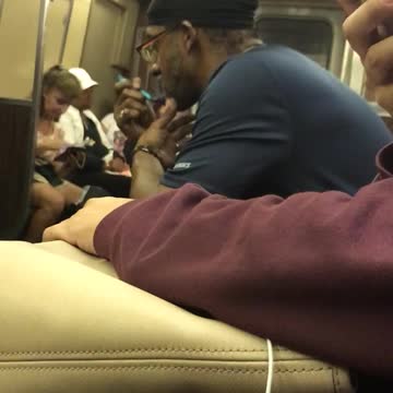 Man in black hat and black shirt shaving