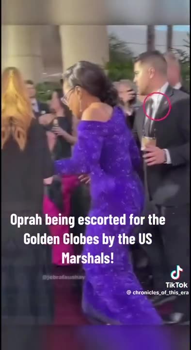 Ophra being escorted into the Golden Globes by US Marshalls.