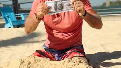 a-man-digging-money-from-the-sand