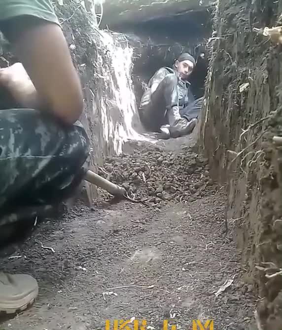 Ukraine forces in trench during Russian artillery strike