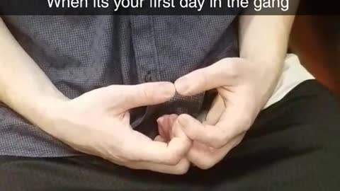 Guy in a blue shirt making symbols with hands