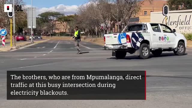 Unemployed brothers directing traffic during loadshedding