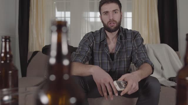 Drunk young man watching television
