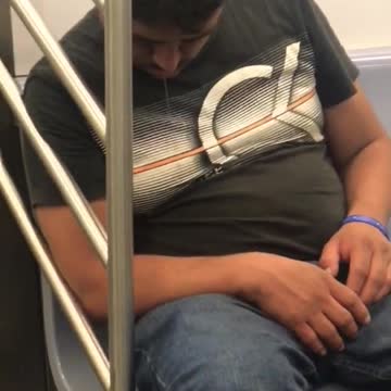 Man asleep on train with drool coming out of mouth