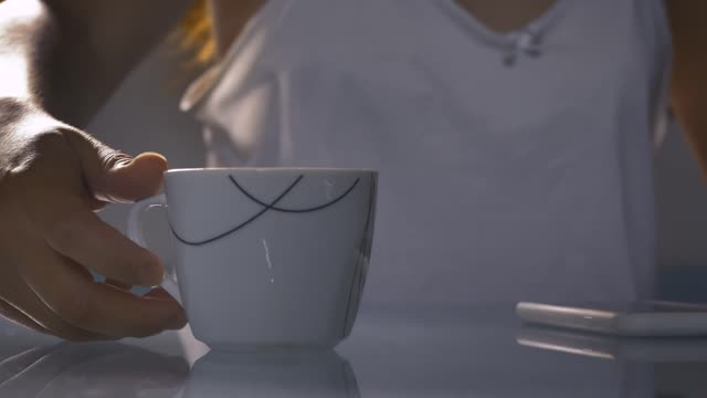 Cup with hot morning coffee in the foreground