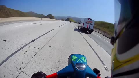 Classic Lambretta scooters on the freeway passing a Harley Davidson van