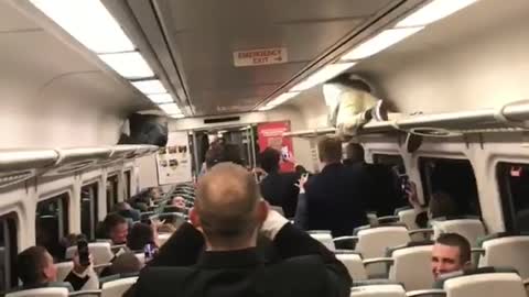 Two guys crawling on train ceiling race