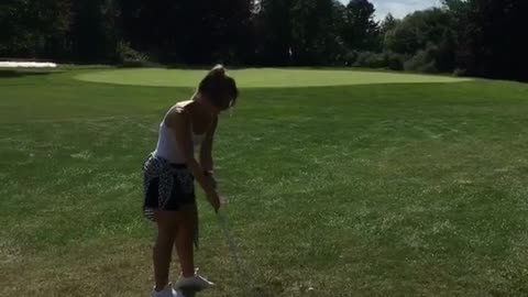 Woman golf shot spins and falls down