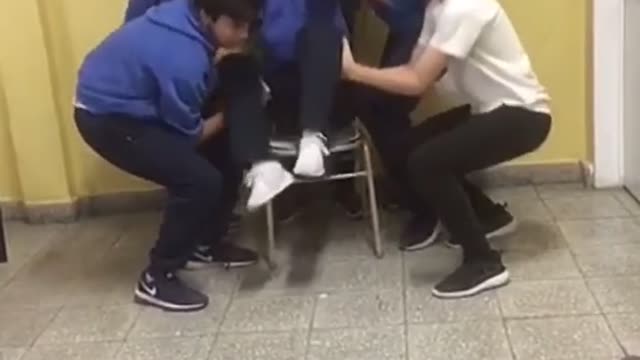 Kids in blue uniform throw a boy in the air