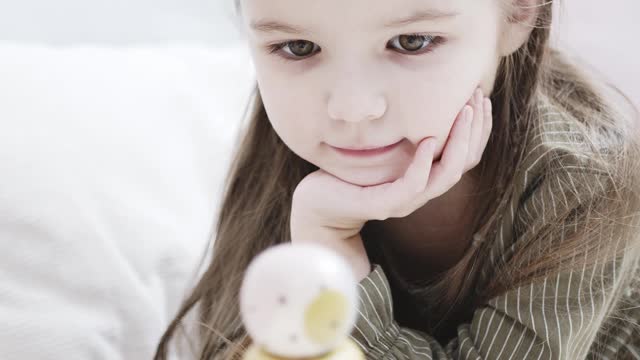 A Cute Little Girl Playing With A Wooden Toy