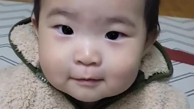 A smiling baby getting ready to go out.