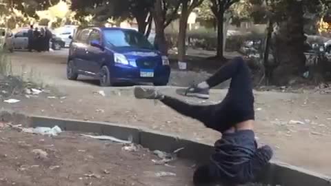 Teen in grey shirt black pants tries to do front flip ends up faceplanting