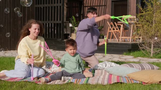 Watch a child with his parents making soap bubbles