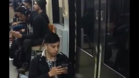 Man on phone texting does splits while on subway