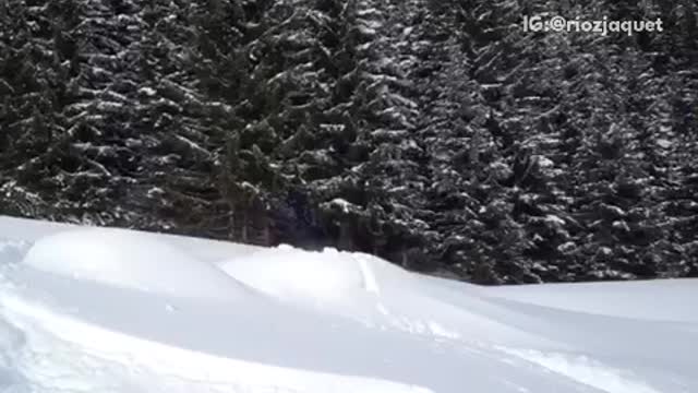 Red sweater white helmet skiier attempts front flip and fails