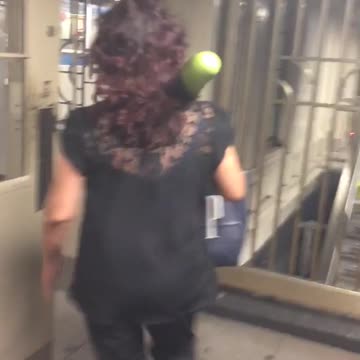 Woman walks down stairs with green toy