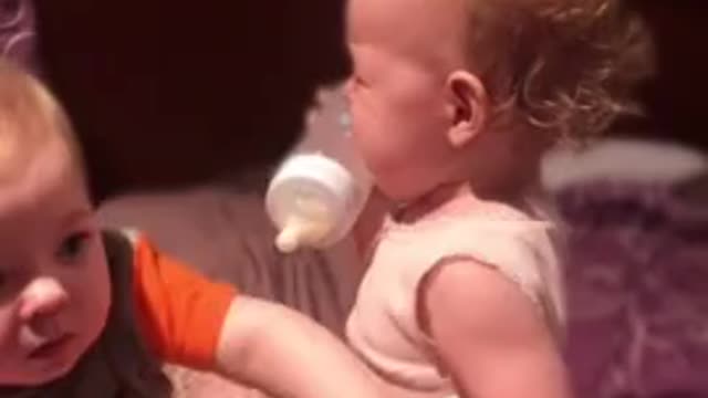 Toddler hilariously attempts to bottle feed his baby brother