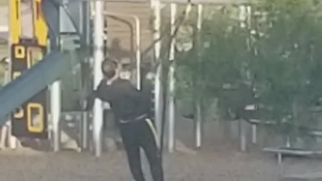 Man in black exercising in playground with ropes