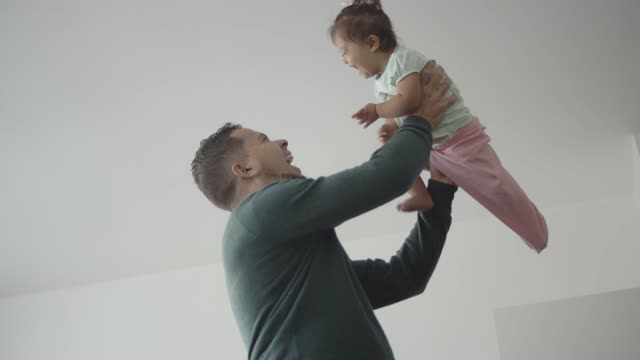A Happy father Lifting a Laughing Baby Girl