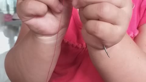 Cute Kid Concentrates to Thread a Needle