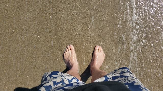 Feet in the beach sand of Palm Beach, Florida