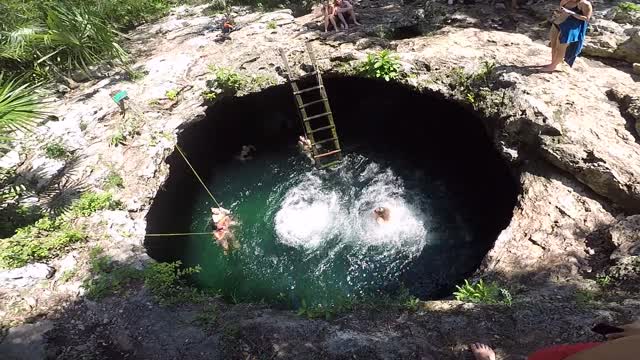 Two Women Jumping Down A Water Hole