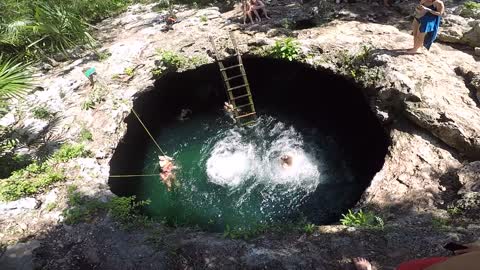 Two Women Jumping Down A Water Hole